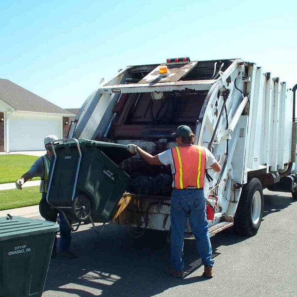 Garbage truck collecting residential waste bins in a neighborhood for Garbage Removal Services Kent WA