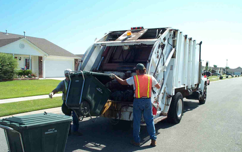 Garbage truck collecting residential waste bins in a neighborhood for Garbage Removal Services Kent WA